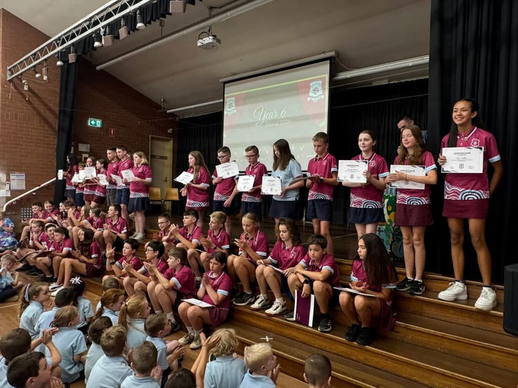 Students on stage receiving awards at assembly.