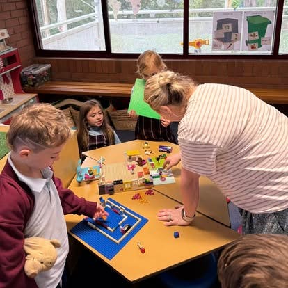 Support teacher helping students with their work.